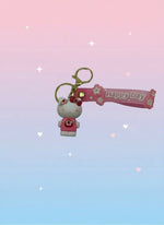 Keychain with cartoon character and 'Happy Day' banner on a gray background