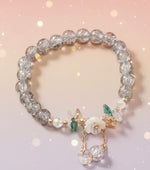 Floral crystal beaded bracelet featuring sparkling crystal beads and floral accents against a soft pastel background.