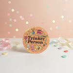Trinket Person Kawaii Vinyl Stickers displayed on a pastel background with colorful confetti and decorative ribbon.