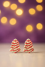 Festive Tree Dessert Earrings displayed with soft bokeh lights in the background, perfect holiday jewelry.