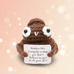 Positive Poo Crochet Doll with Wooden Stand holding a sign with an uplifting message.