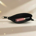 Vintage sardine coin purse with a lipstick inside, showcasing a compact design and zipper closure.