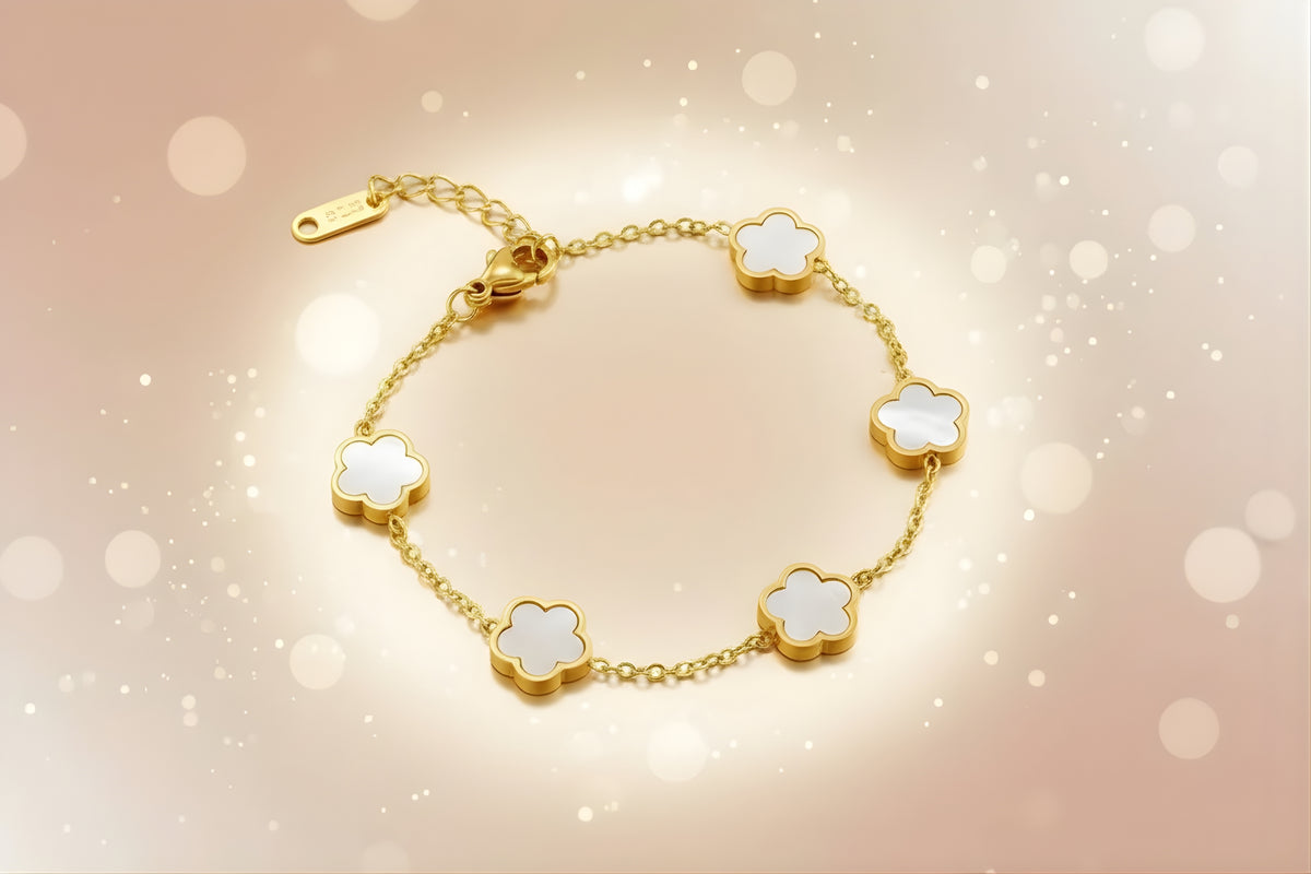 Clover charm bracelet featuring gold plated design with white clover flower motifs on a delicate chain.