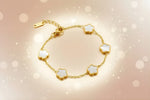 Clover charm bracelet featuring gold plated design with white clover flower motifs on a delicate chain.