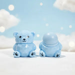 Handmade Bear Lip Balm in blue bear shape, featuring a glossy finish and playful design against a soft sky backdrop.