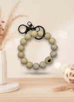 Silicone Wristlet Keychain in beige with decorative beads, perfect as a holiday gift or stocking stuffer.