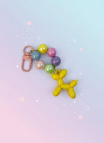 Keychain with colorful beads and a balloon dog charm on a white background