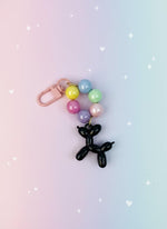 Keychain with balloon dog charm and colorful beads on a white background