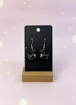 black duck earrings with white skeleton on it