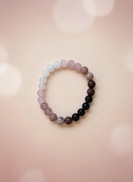 Beaded bracelet with a brown cardboard holder on a white background