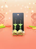 Taco and margarita earrings on a black card with a white background