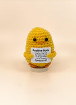 Emotional support duck plushie holding a sign that says 'You’re Ducking Awesome!' for encouragement.