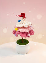 Mini Crochet Christmas Tree Ornament in pink and white with pom poms and red topper, perfect handmade holiday decor.