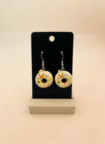 Cute Animal Donut Earrings displayed on a stand with colorful donut designs and animal faces, handmade resin charm jewelry.