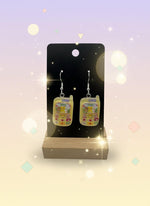 Adorable Kawaii Phone Earrings displayed on a wooden stand against a pastel background.