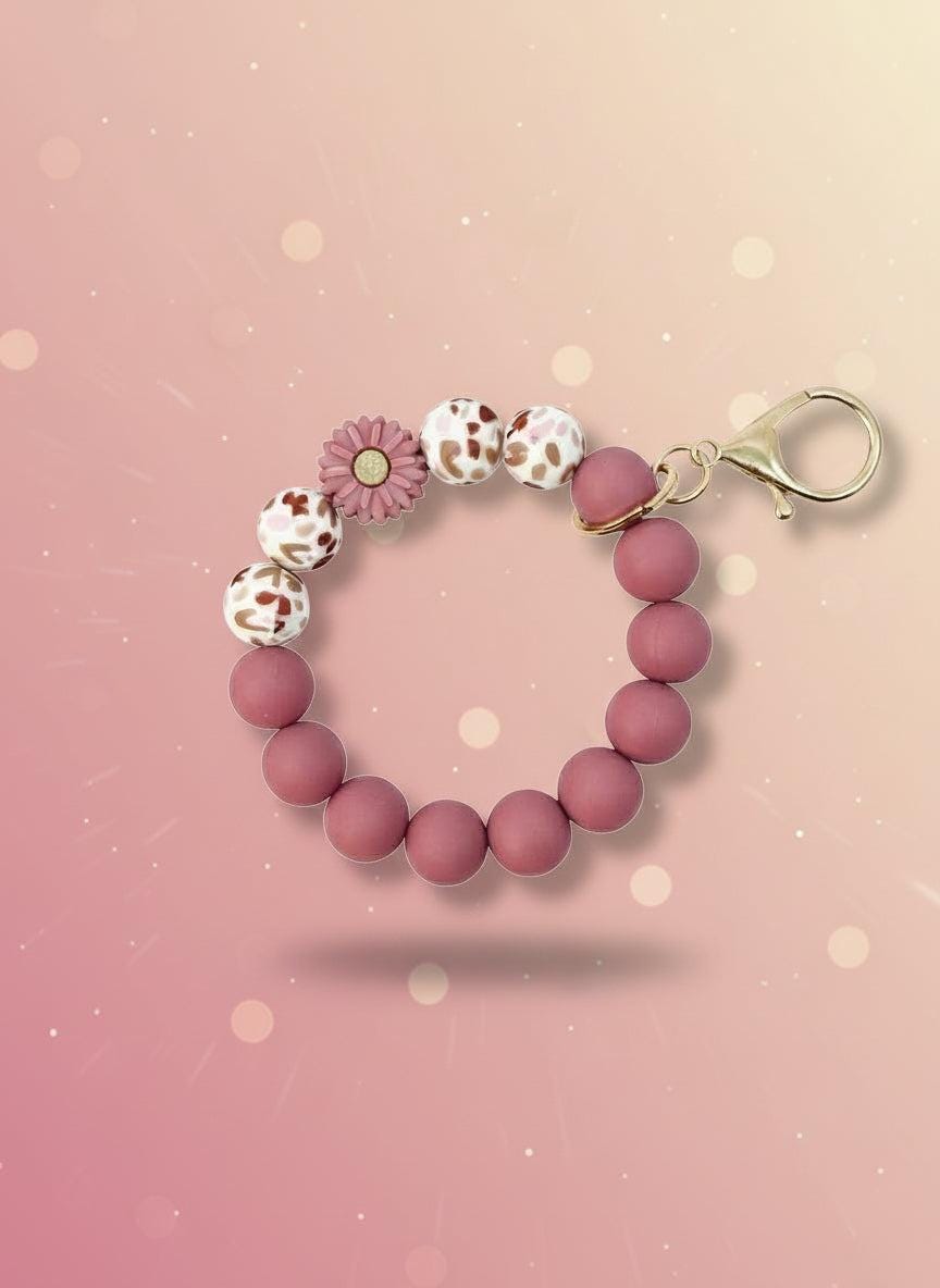 Silicone Wristlet Keychain featuring a pink beaded design with a flower charm, perfect for everyday use and gifting.