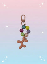 Colorful balloon dog keychain with beads on a white background