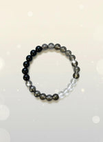 Beaded bracelet with black, brown, and clear beads on a white background